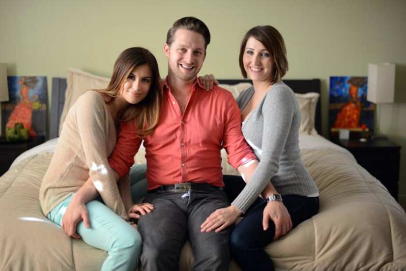 Two Women on Bed with Man Photo