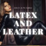 Woman in a black latex catsuit and leather boots posing confidently in a dimly lit interior setting.